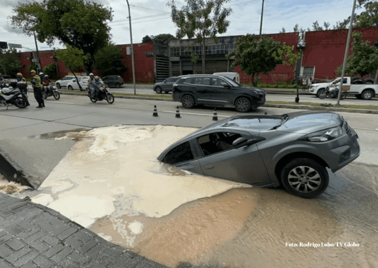 Carro é ‘engolido’ por cratera após asfalto ceder em avenida